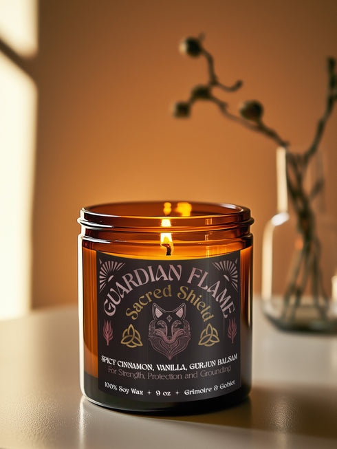 Amber glass jar with Guardian Flame label featuring a metallic wolf and flame motifs in pink and gold. Spicy cinnamon, vanilla, and gurjun balsam candle. 9 oz soy candle by Grimoire & Goblet.